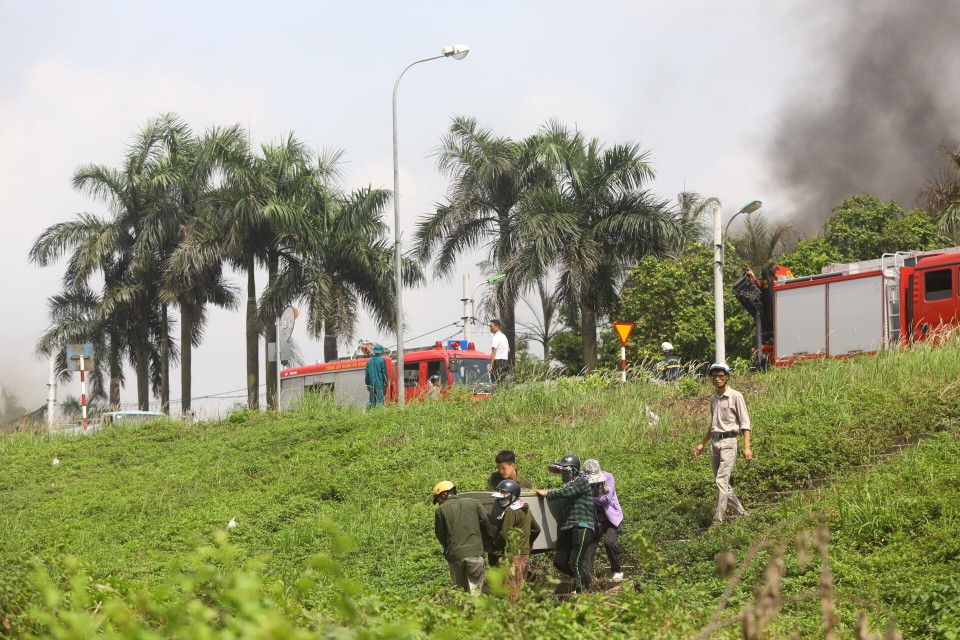 Một số người dân cố gắng vận chuyển đồ đạc ra khỏi hiện trường vụ cháy. (Ảnh: TTXVN)