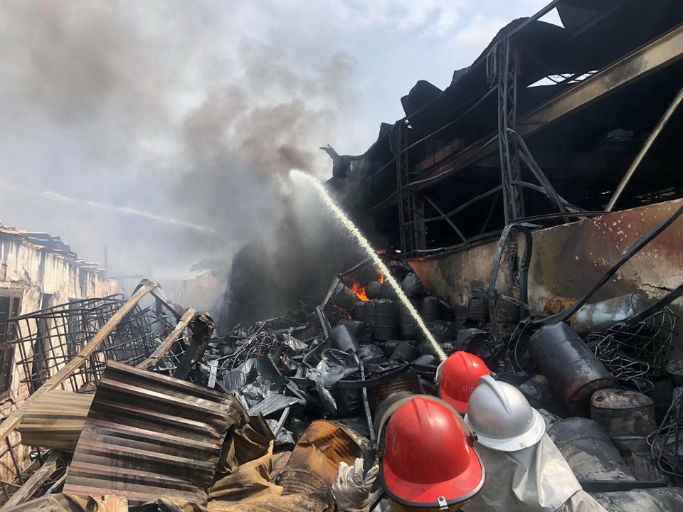 Lực lượng chữa cháy phun nước dập lửa. (Ảnh: TTXVN)