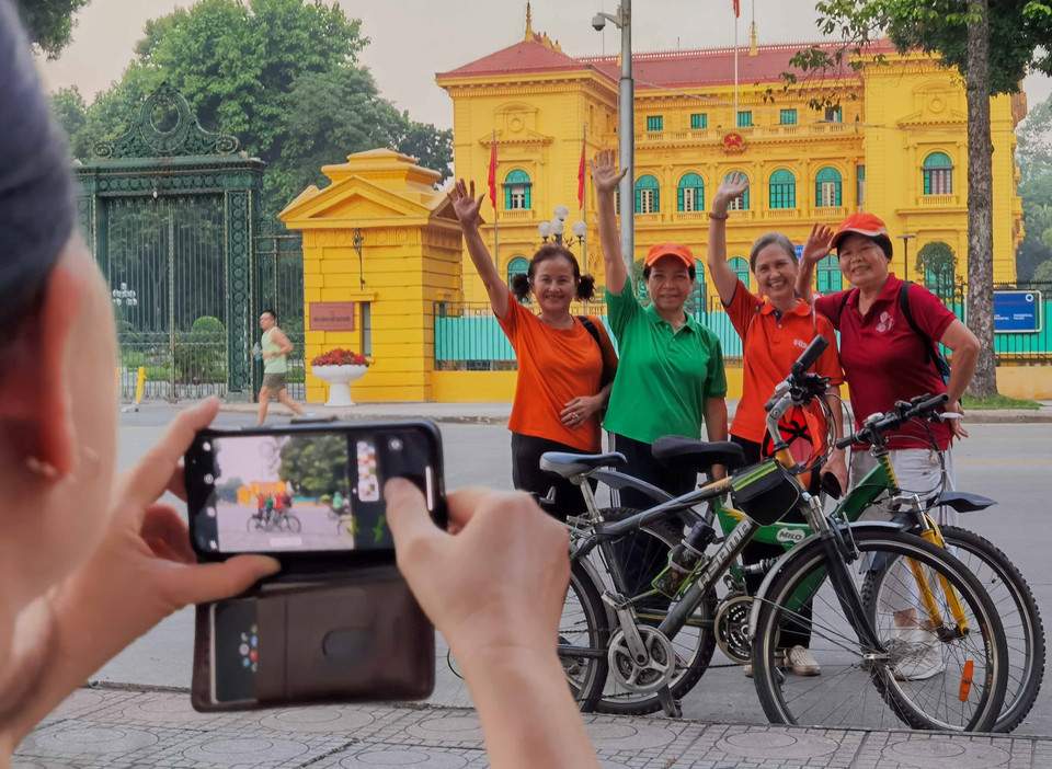 Người dân Thủ đô đạp xe thể dục buổi sáng lưu lại khoảnh khắc một sớm Thu tháng Chín tại Phủ Chủ tịch. (Ảnh: Thanh Tùng/TTXVN)