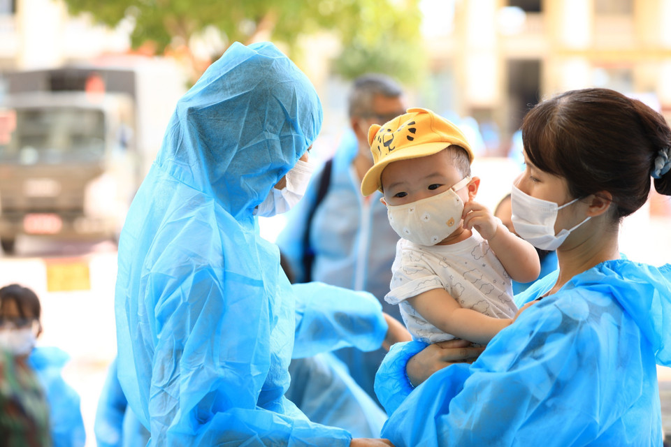 Một gia đình chờ làm thủ tục tại khu cách ly tập trung Trường quân sự Bộ Tư lệnh Thủ đô. (Ảnh: Thành Đạt/TTXVN)