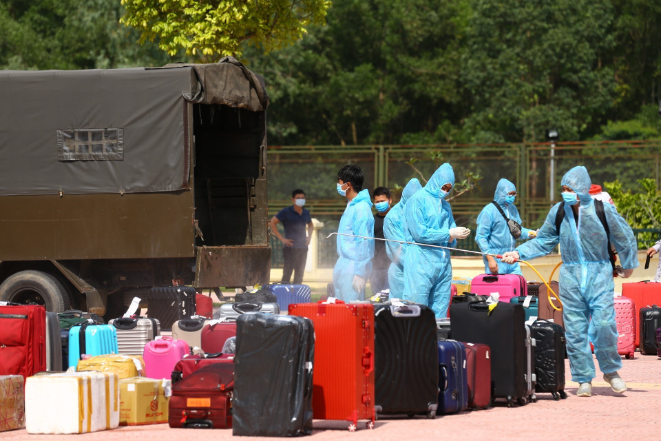 Phun khử khuẩn hành lý của người về từ Đà Nẵng tại khu cách ly tập trung Trường quân sự Bộ Tư lệnh Thủ đô. (Ảnh: Minh Quyết/TTXVN)