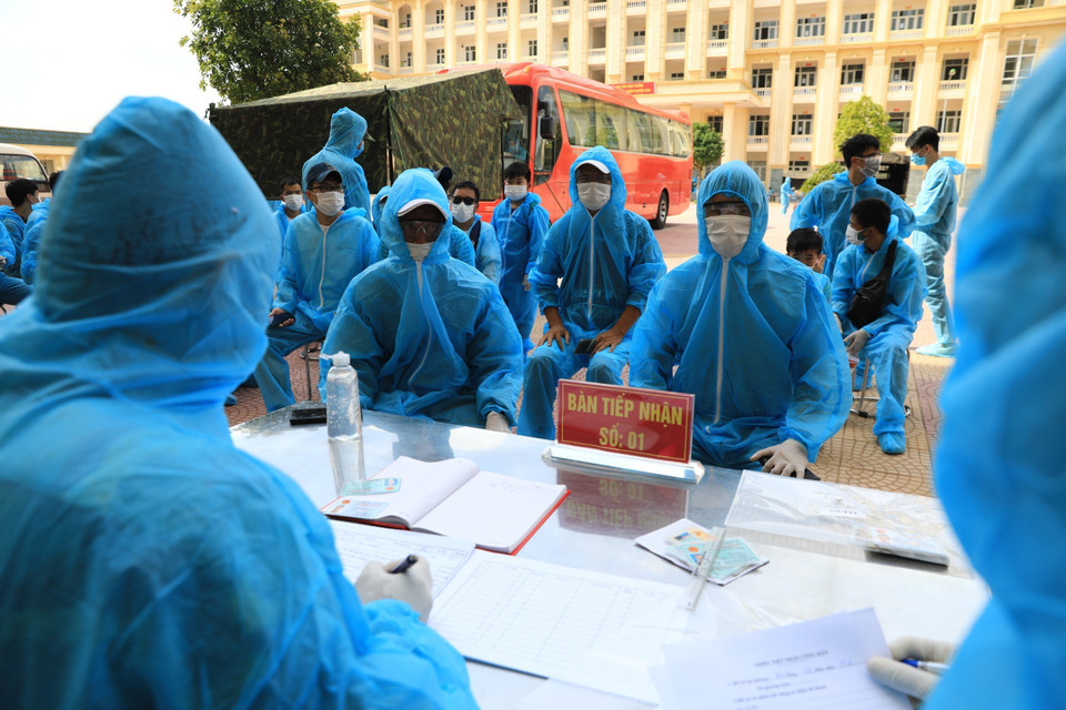 Làm thủ tục tiếp nhận hành khách về từ Đà Nẵng, tại khu cách ly tập trung Trường quân sự Bộ Tư lệnh Thủ đô. (Ảnh: Thành Đạt/TTXVN)