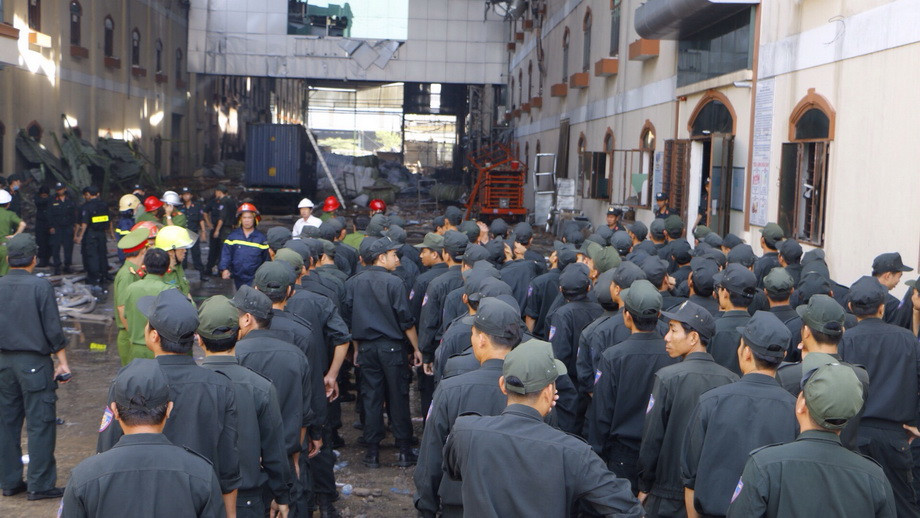 Đưa phương tiện máy móc tiếp cận hiện trường để dập tắt ngọn lửa. (Ảnh: Thanh Liêm/TTXVN)