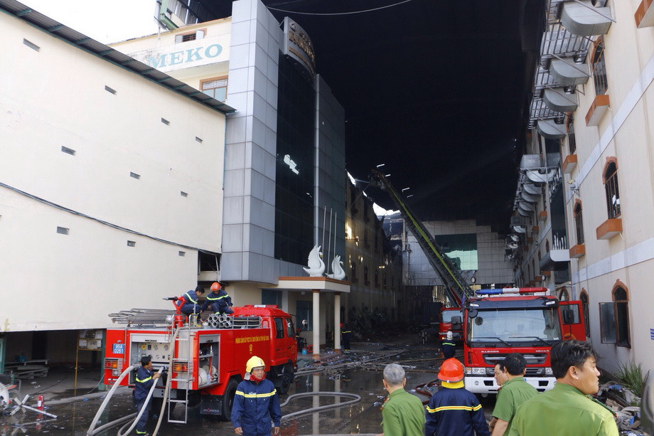 Đưa phương tiện máy móc tiếp cận hiện trường để dập tắt ngọn lửa. (Ảnh: Thanh Liêm/TTXVN)