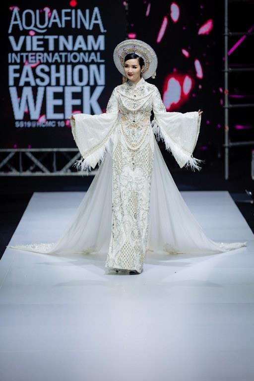 Sở hữu vóc dáng chuẩn cùng vẻ đẹp kiêu sa, Hoa hậu Đền Hùng Giáng My trở thành lựa chọn mở màn của nhà thiết kế Lê Long Dũng. Khoác lên mình trang phục áo dài trắng đính đá, pha lê lấp lánh thêm phần tà có chiều dài 'khủng,' người đẹp Giáng My vẫn sải bước duyên dáng và thanh thoát dù trang phục của cô nặng đến 25 kg, theo chia sẻ của nhà thiết kế.(Ảnh: CTV)