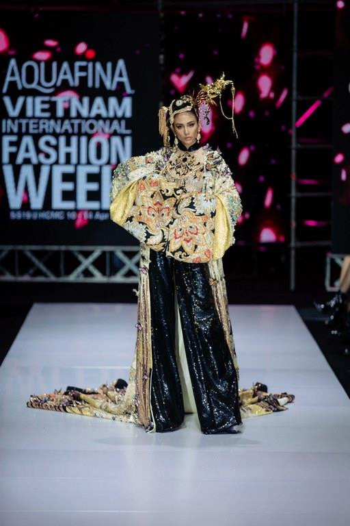 Vedette Võ Hoàng Yến trong tà áo dài với phần áo choàng được đính kết thủ công tông màu vàng-đen đầy quyền uy đã tái hiện thành công hình ảnh của một nàng tiểu thư đài các. Nữ siêu mẫu cũng bị làm khó với bộ trang phục nặng hơn 25kg mà nhà thiết kế chế tác đặc biệt dành cho vị trí vedette. (Ảnh: CTV)