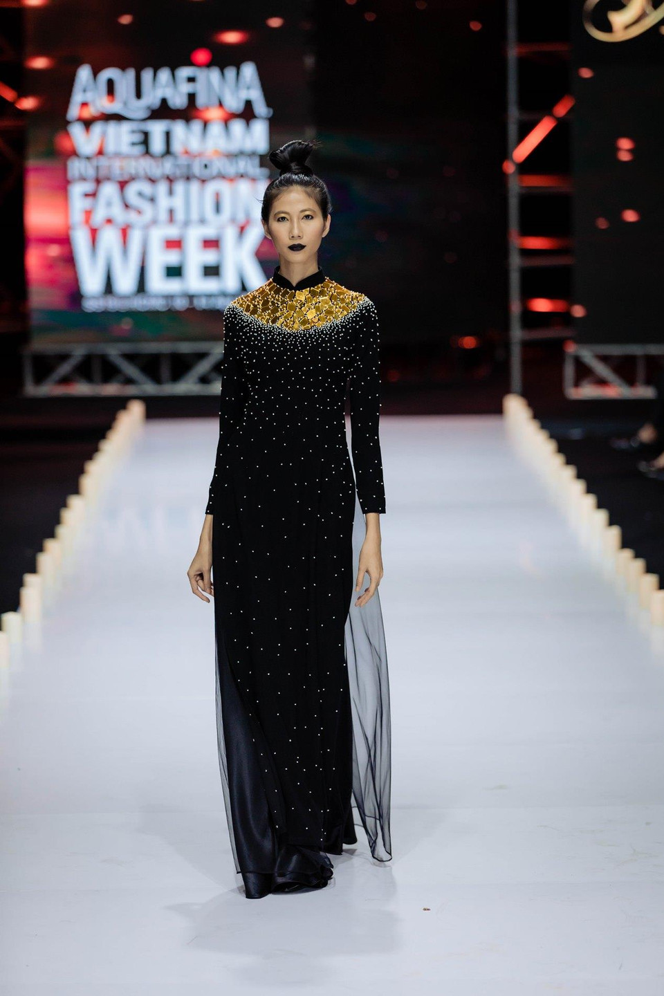 Hàng trăm cây nến trải dọc theo sàn catwalk đã thắp lên một không gian ấm áp dẫn lối cho thông điệp ý nghĩa ấy truyền tải vào những tà áo dài. (Ảnh: CTV)