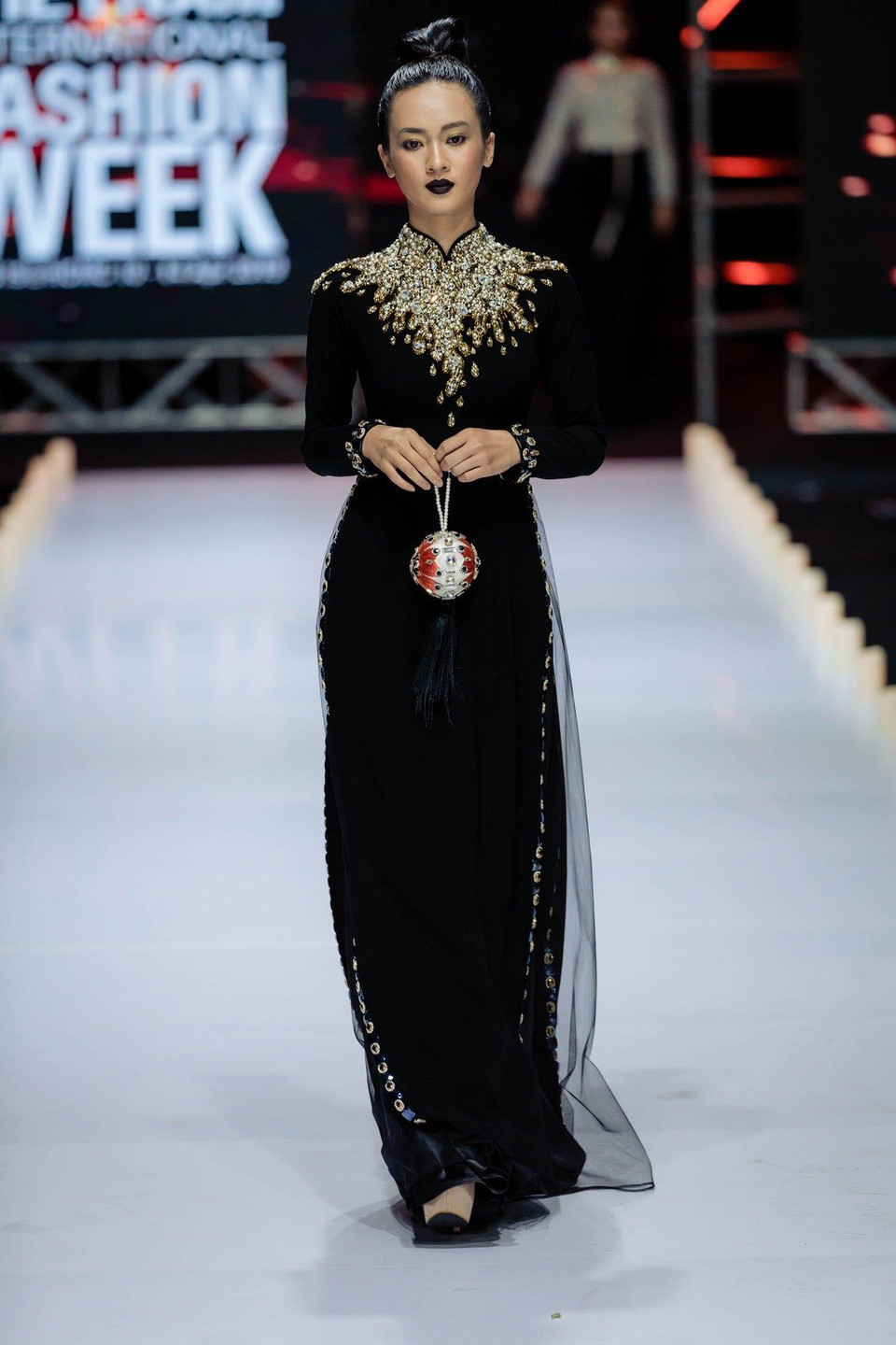 Hình ảnh dàn mẫu trên tay là phụ kiện kết hoa, đôi môi đen, tóc búi cao để lộ chiếc cổ và bờ vai thanh thoát, khoác lên những tà áo dài ngời chất ‘Kim’ chắc chắn là một khoảnh khắc ấn tượng và khó quên đối với những người yêu thời trang đã theo dõi bộ sựu tập mới của nhà thiết kế Minh Châu. (Ảnh: CTV)