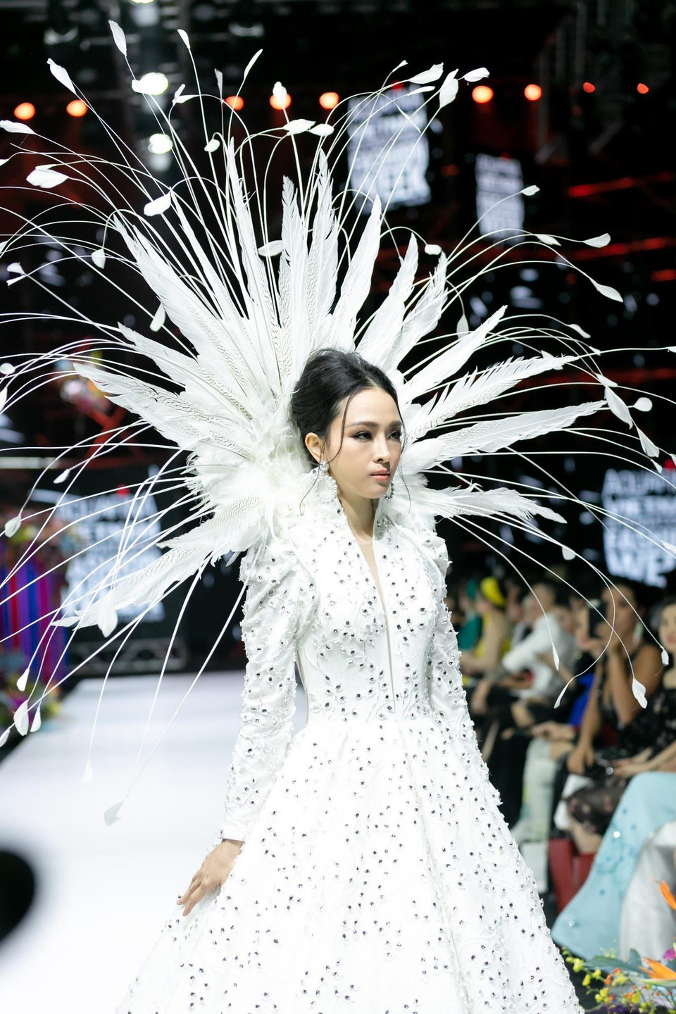Điểm nhấn của show diễn là vedette Hoa hậu Trương Hồ Phương Nga trong mẫu váy trắng tinh khôi được đầu tư 'khủng' từ chất liệu, kiểu dáng đến phụ kiện mũ lông vũ ấn tượng. (Ảnh: CTV)