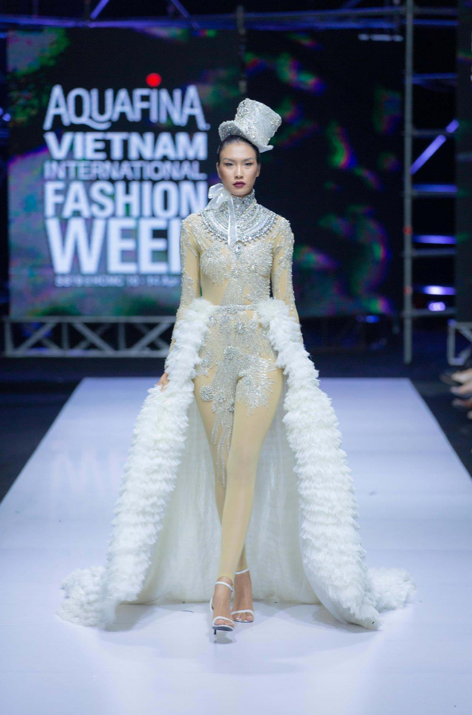 Frederick Lee khép lại buổi trình diễn cùng bộ trang phục ấn tượng nhất. Nổi bật trên đường băng là thiết kế jumpsuit trắng được đính kết kỳ công với phần tùng váy xếp li tháo rời. (Ảnh: CTV)