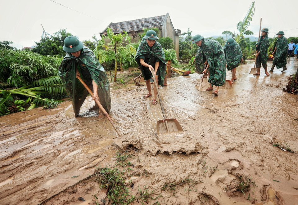 Cán bộ, chiến sỹ Sư đoàn 325 dọn dẹp sình lầy tại thôn Khả Lã, xã Tân Lập, Lục Ngạn. (Ảnh: Danh Lam/TTXVN)