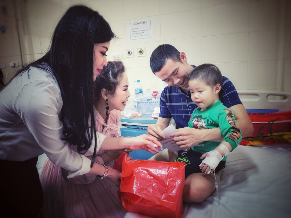 Các bệnh nhi và gia đình nhận món quà đầu Xuân mới từ các Đại sứ Nhân ái của chương trình Áo dài Phu nhân toàn châu Âu. (Ảnh: Xuân Mai/Vietnam+)