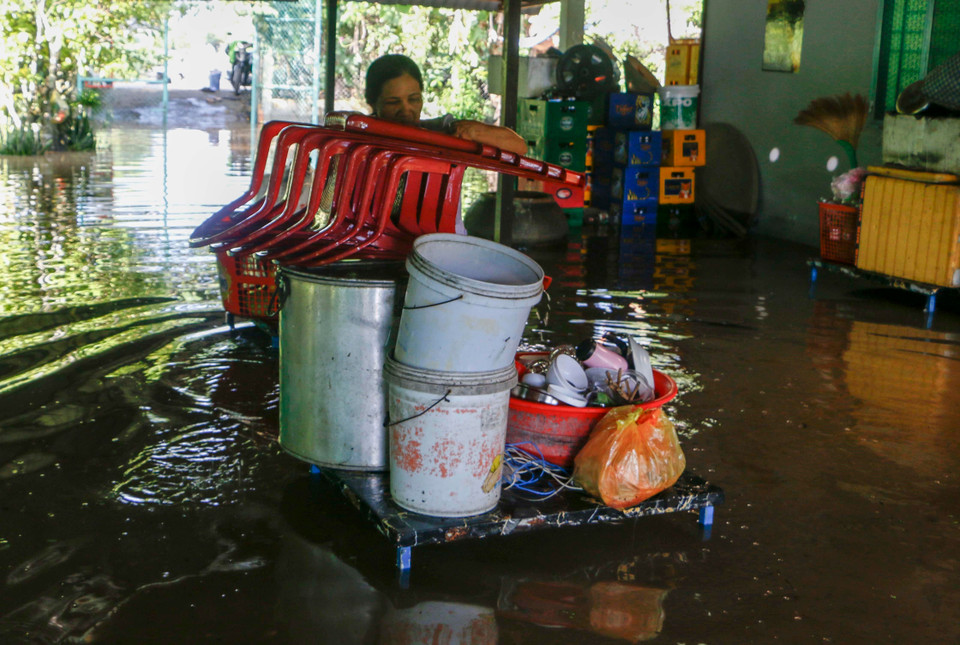 Chủ một quán ăn ở Cồn Khương, phường Cái Khế, quận Ninh Kiều di dời đồ đạc bị ngập do triều cường. (Ảnh: Thanh Liêm/TTXVN)
