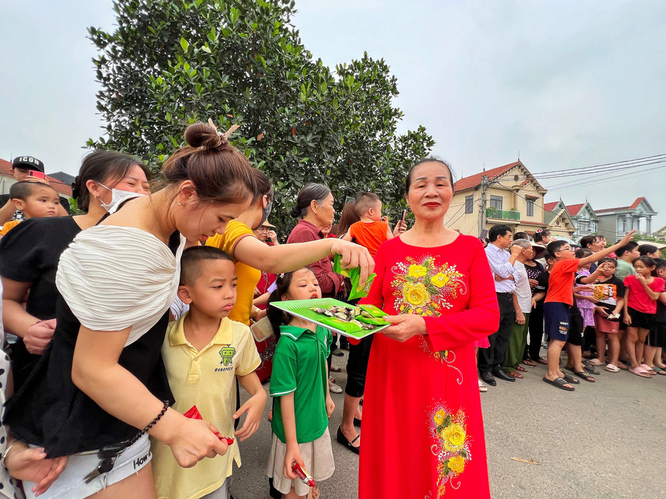 Người dân làng từ trẻ con, người lớn và cả các bậc cao niên tập trung rất đông cổ vũ đoàn rước kiệu. (Ảnh: Mai Mai/Vietnam+)