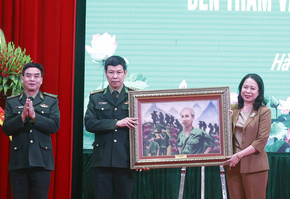 Quyền Chủ tịch nước Võ Thị Ánh Xuân tặng bức tranh 'Bác đang cùng chúng cháu hành quân' cho Học viện Biên phòng. (Ảnh: Thống Nhất/TTXVN)