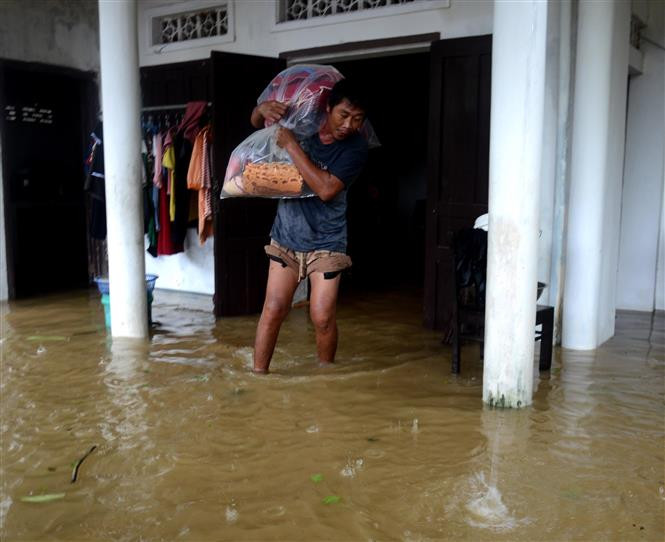 Người dân di dời đồ đạc đến vị trí cao ráo để tránh lũ. (Ảnh: Lê Ngọc Phước/TTXVN)