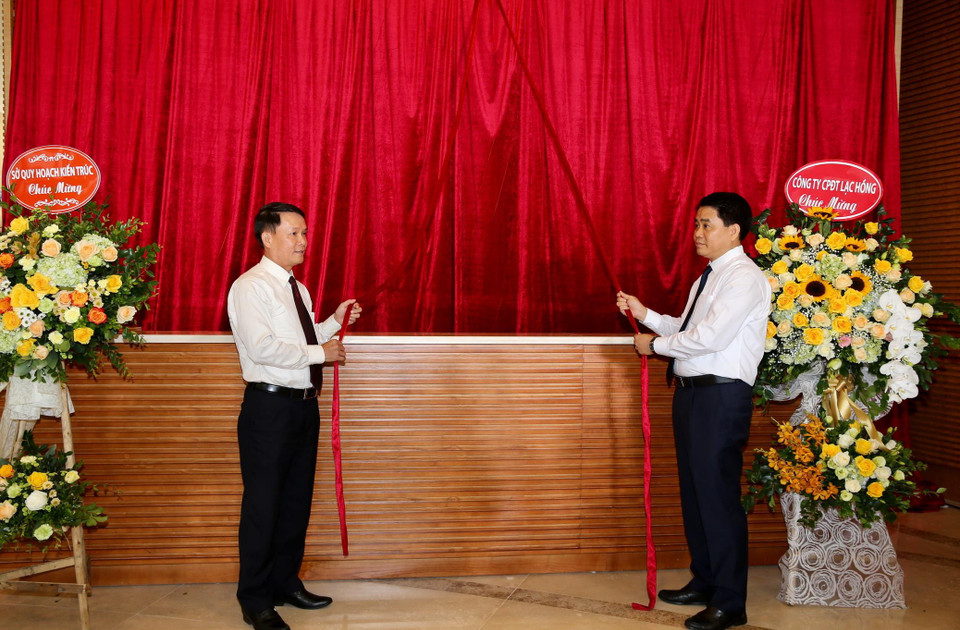 Tổng Giám đốc Thông tấn xã Việt Nam Nguyễn Đức Lợi và Chủ tịch Ủy ban Nhân dân thành phố Hà Nội Nguyễn Đức Chung kéo băng khai trương Trung tâm Truyền hình Thông tấn. (Ảnh: Dương Giang/TTXVN)