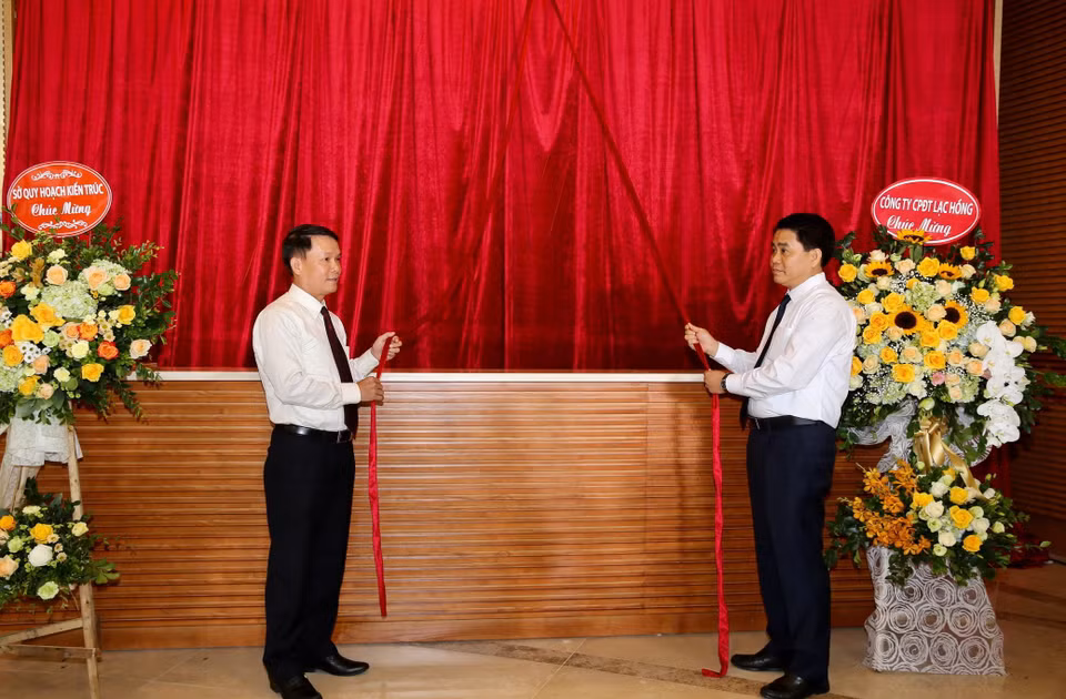 Tổng Giám đốc Thông tấn xã Việt Nam Nguyễn Đức Lợi và Chủ tịch Ủy ban Nhân dân thành phố Hà Nội Nguyễn Đức Chung kéo băng khai trương Trung tâm Truyền hình Thông tấn. (Ảnh: Dương Giang/TTXVN)