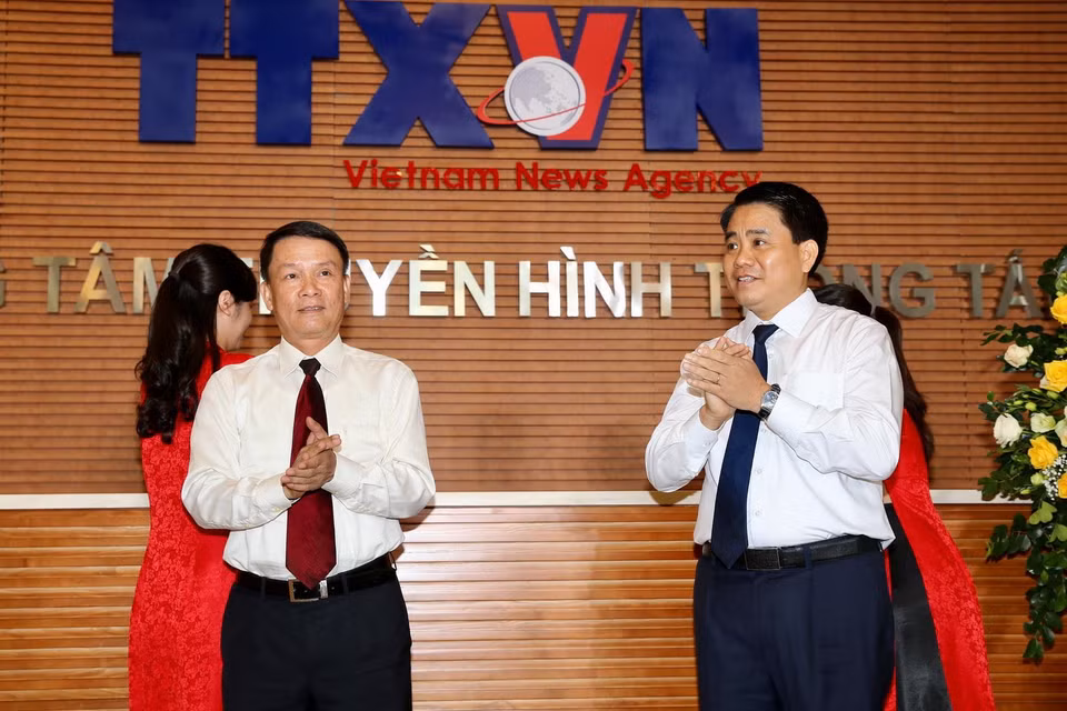 Tổng Giám đốc Thông tấn xã Việt Nam Nguyễn Đức Lợi và Chủ tịch Ủy ban Nhân dân thành phố Hà Nội Nguyễn Đức Chung kéo băng khai trương Trung tâm Truyền hình Thông tấn. (Ảnh: Dương Giang/TTXVN)