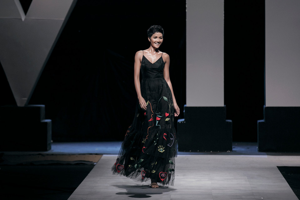 Hoa hậu Hoàn Vũ Việt Nam H’Hen Niê gợi cảm một cách khỏe khoắn trong chiếc đầm hai dây màu đen tuyền, thêu kết những họa tiết có phong cách đại chúng độc đáo.