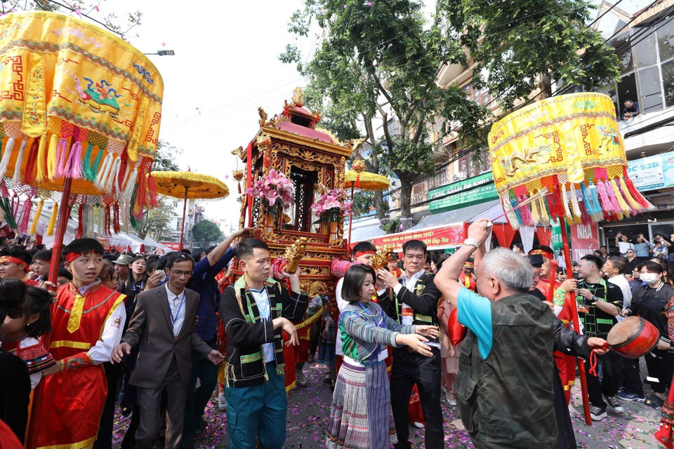 Một người dân hành lễ trước kiệu rước. (Ảnh: Anh Tuấn/TTXVN)