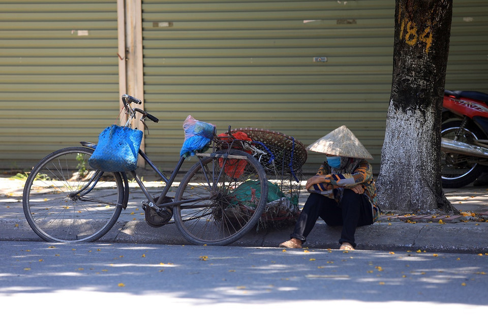 Phút nghỉ ngơi dưới bóng mát của một người bán hàng rong.(Ảnh: Phan Tuấn Anh/TTXVN)