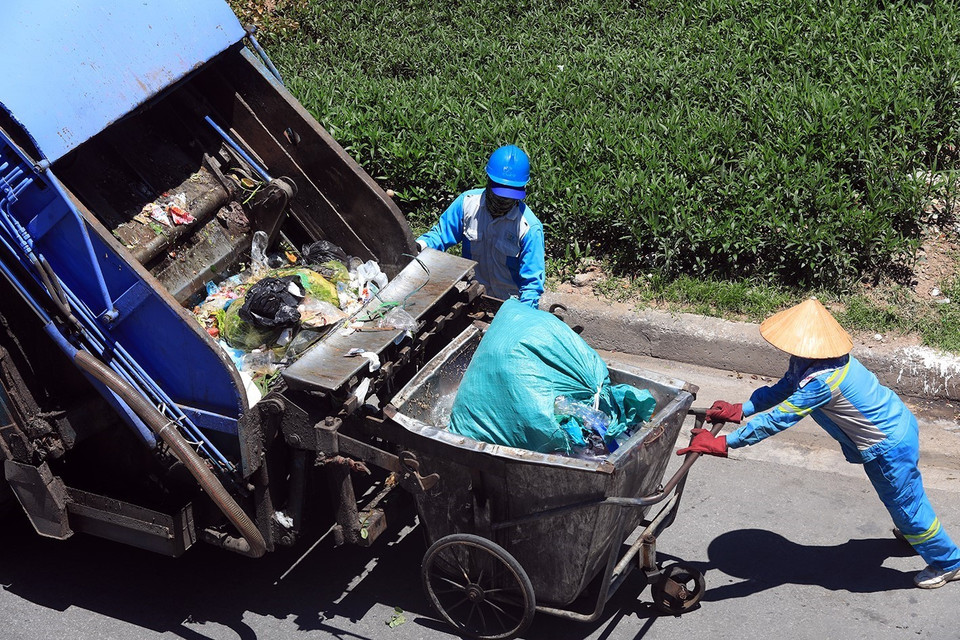 Công nhân Công ty TNHH một thành viên Môi trường và Đô thị (URENCO) phải làm việc dưới cái nắng trên 40 độ C. (Ảnh: Phan Tuấn Anh/TTXVN)