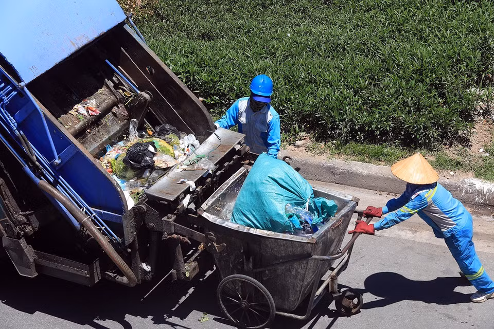 Công nhân Công ty TNHH một thành viên Môi trường và Đô thị (URENCO) phải làm việc dưới cái nắng trên 40 độ C. (Ảnh: Phan Tuấn Anh/TTXVN)