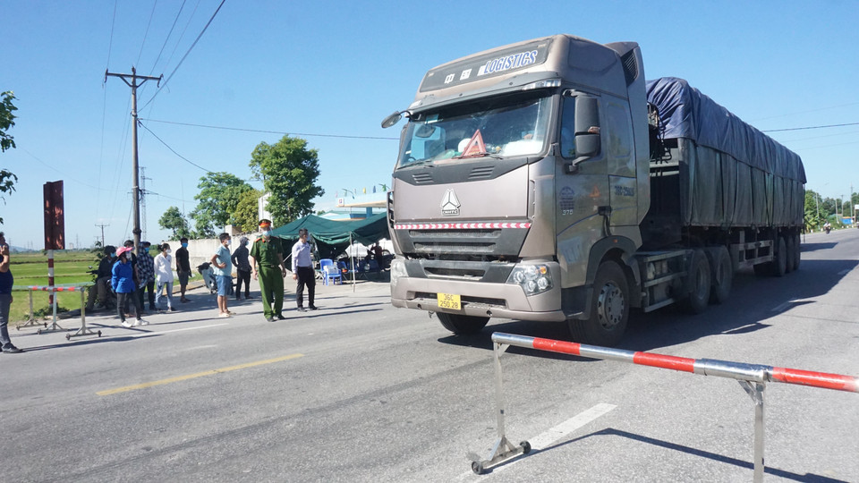 Theo quy định, các xe chở hàng, chở nguyên vật liệu phục vụ sản xuất vẫn được lưu thông ra vào thành phố với điều kiện lái xe xuất trình giấy tờ tại điểm chốt trên Quốc lộ 46 tại xã Hưng Đông để qua chốt. (Ảnh: Bích Huệ/TTXVN)