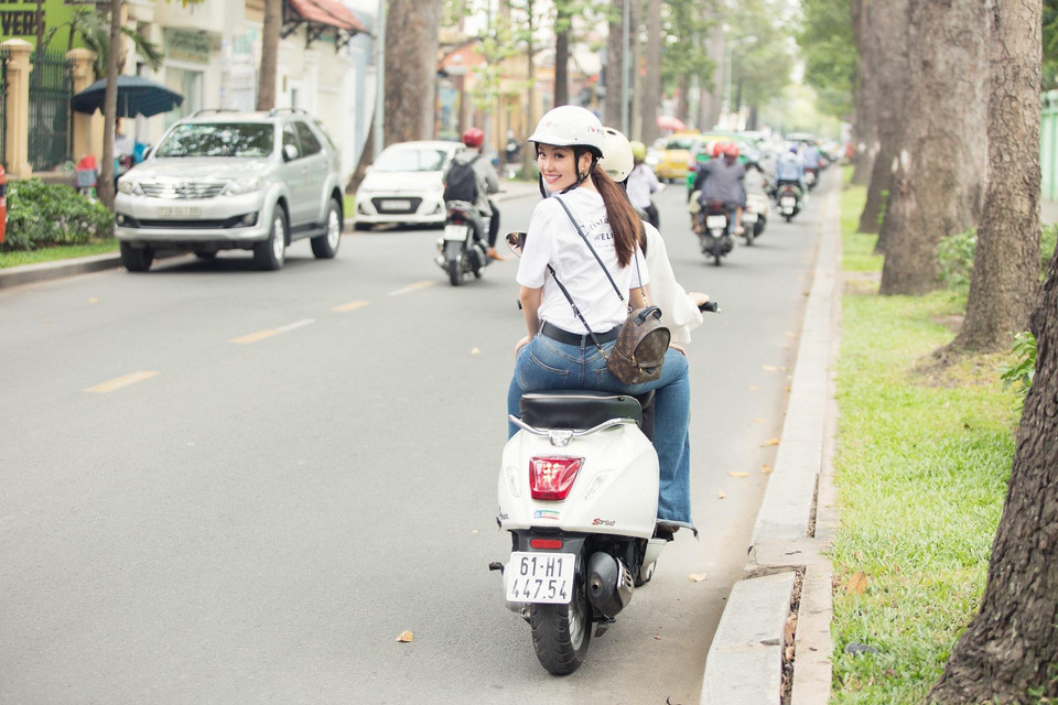 Diện trang phục khỏe khoắn, năng động, hai nàng hậu rạng rỡ xuống phố, cùng nhau vi vu trên những cung đường của Sài Gòn để đưa khán giả đến với những địa điểm ăn vặt 'healthy' (có lợi cho sức khỏe) nằm trong kho bí quyết của hai cô nàng. (Ảnh: Tân Lê/Vietnam+) 