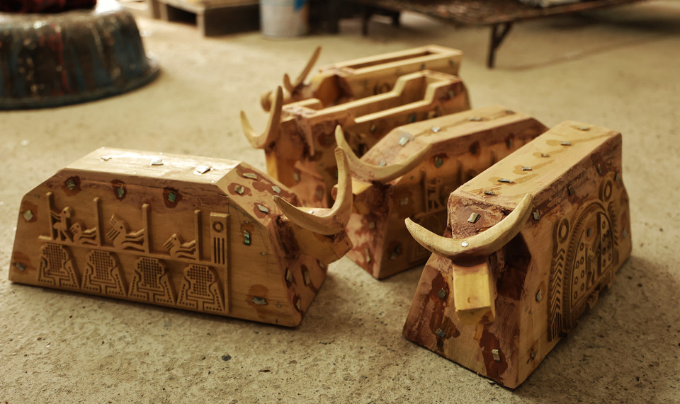 Nghệ nhân cho hay mỗi 'đứa con' phải trải qua hàng chục công đoạn, từ lên ý tưởng, rồi đục, đẽo tạo dáng cho khối gỗ, sau đó phủ lên nhiều lớp sơn, phơi khô, đánh bóng, khảm trai, vẽ tạo tác... nên nhanh thì vài ngày, lâu thì cả tháng mới 'chào đời.' (Ảnh: Xuân Mai/Vietnam+)