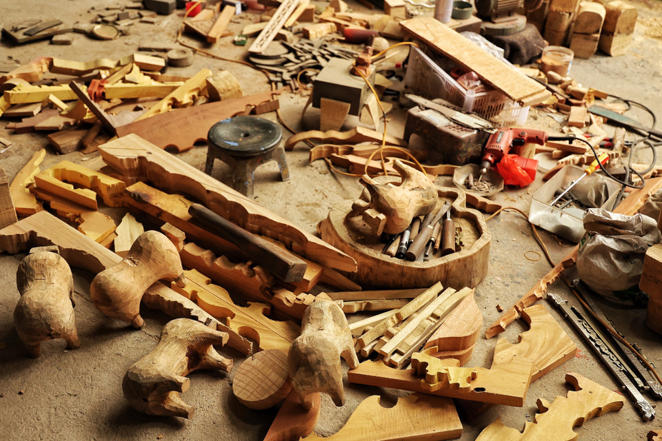 Ghé thăm xưởng của nghệ nhân Nguyễn Tấn Phát vào ngày đầu Xuân năm mới, mọi công việc của dự án 1010 con trâu sơn mài vẫn ngổn ngang với gỗ, khoan, cưa, đục... (Ảnh: Xuân Mai/Vietnam+)