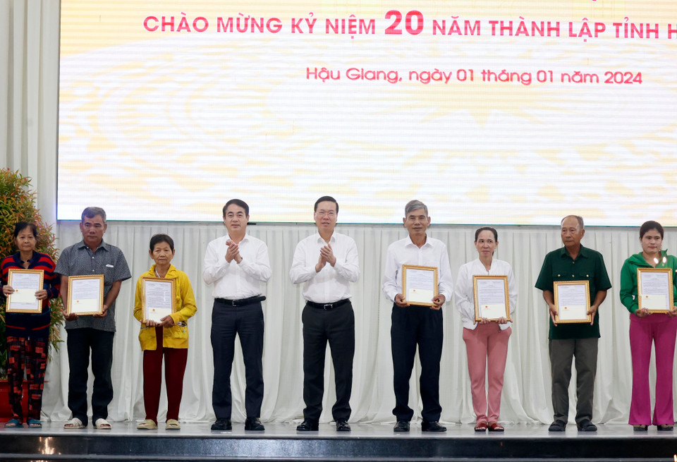 Chủ tịch nước Võ Văn Thưởng trao biểu trưng nhà Đại đoàn kết cho các gia đình tỉnh Hậu Giang. (Ảnh: Thống Nhất/TTXVN)