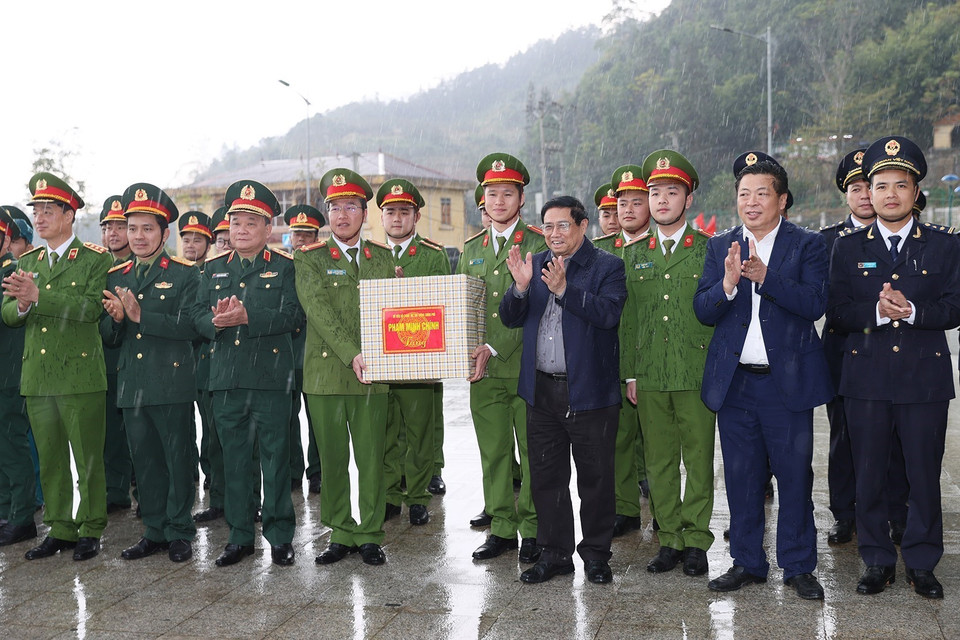 Thủ tướng Phạm Minh Chính tặng quà các lực lượng đang thực hiện nhiệm vụ tại Cửa khẩu Quốc tế Trà Lĩnh. (Ảnh: Dương Giang-TTXVN)