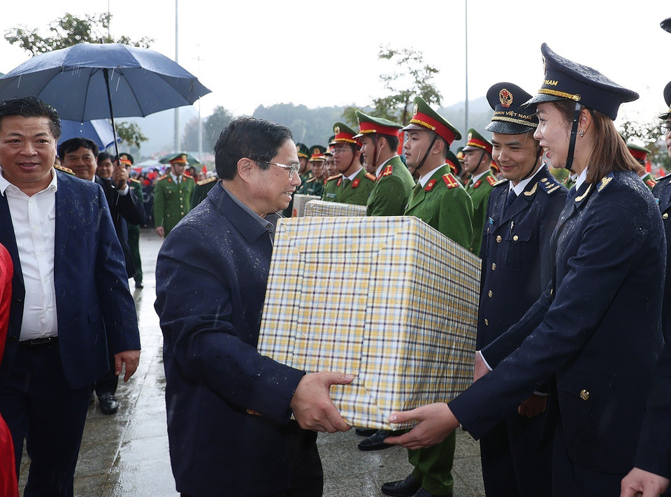 Thủ tướng Phạm Minh Chính tặng quà các lực lượng đang thực hiện nhiệm vụ tại Cửa khẩu Quốc tế Trà Lĩnh. (Ảnh: Dương Giang/TTXVN)