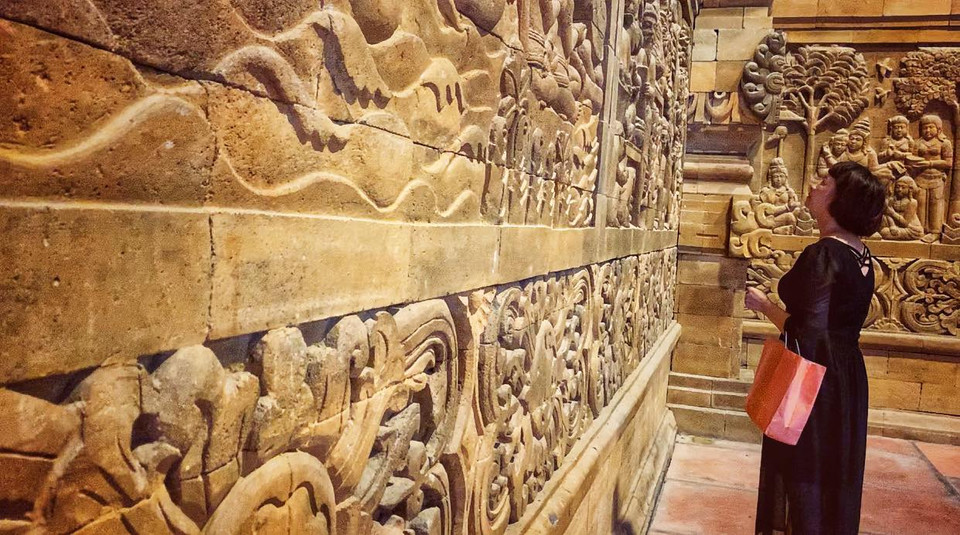 Hầu hết các Phật tử và du khách đến đây đều vô cùng ấn tượng với các bức tường phù điêu làm từ đá núi lửa này. (Ảnh: Xuân Mai/Vietnam+)