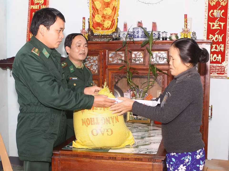 Cán bộ Đồn Biên phòng Mỹ Thủy (Quảng Trị) trực tiếp mang gạo từ 'Hũ gạo tình thương' hỗ trợ cho gia đình bà Lê Thị Kiêm ở thôn Trung An, xã Hải Khê, huyện Hải Lăng. (Ảnh: Hồ Cầu/TTXVN)