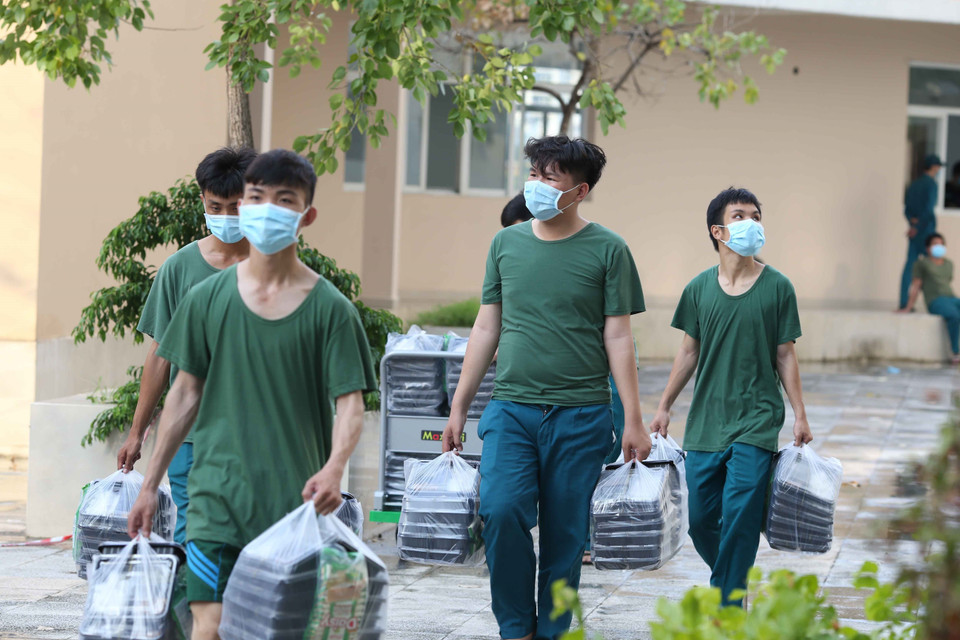  Các chiến sỹ quân đội hỗ trợ công tác vận chuyển các suất ăn từ ngoài vào các khu điều trị bệnh nhân COVID-19. (Ảnh: Xuân Khu)