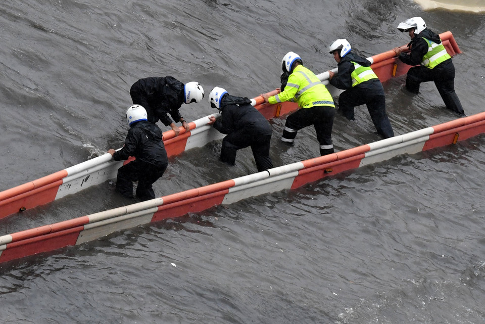 Cảnh sát sửa chữa thiết bị điều khiển giao thông trên tuyến đường bị ngập lụt do mưa lớn kéo dài tại thủ phủ Trịnh Châu, tỉnh Hà Nam, Trung Quốc ngày 20/7/2021. (Ảnh: THX/TTXVN)