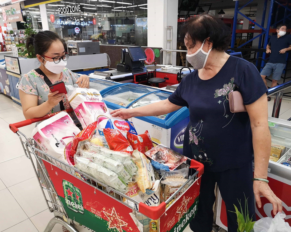 Nhiều người do tâm lý không tốt đã mua nhiều đồ tại siêu thị VinMart Times City trong sáng 24/7 để tích trữ. (Ảnh: Thanh Tùng/TTXVN)