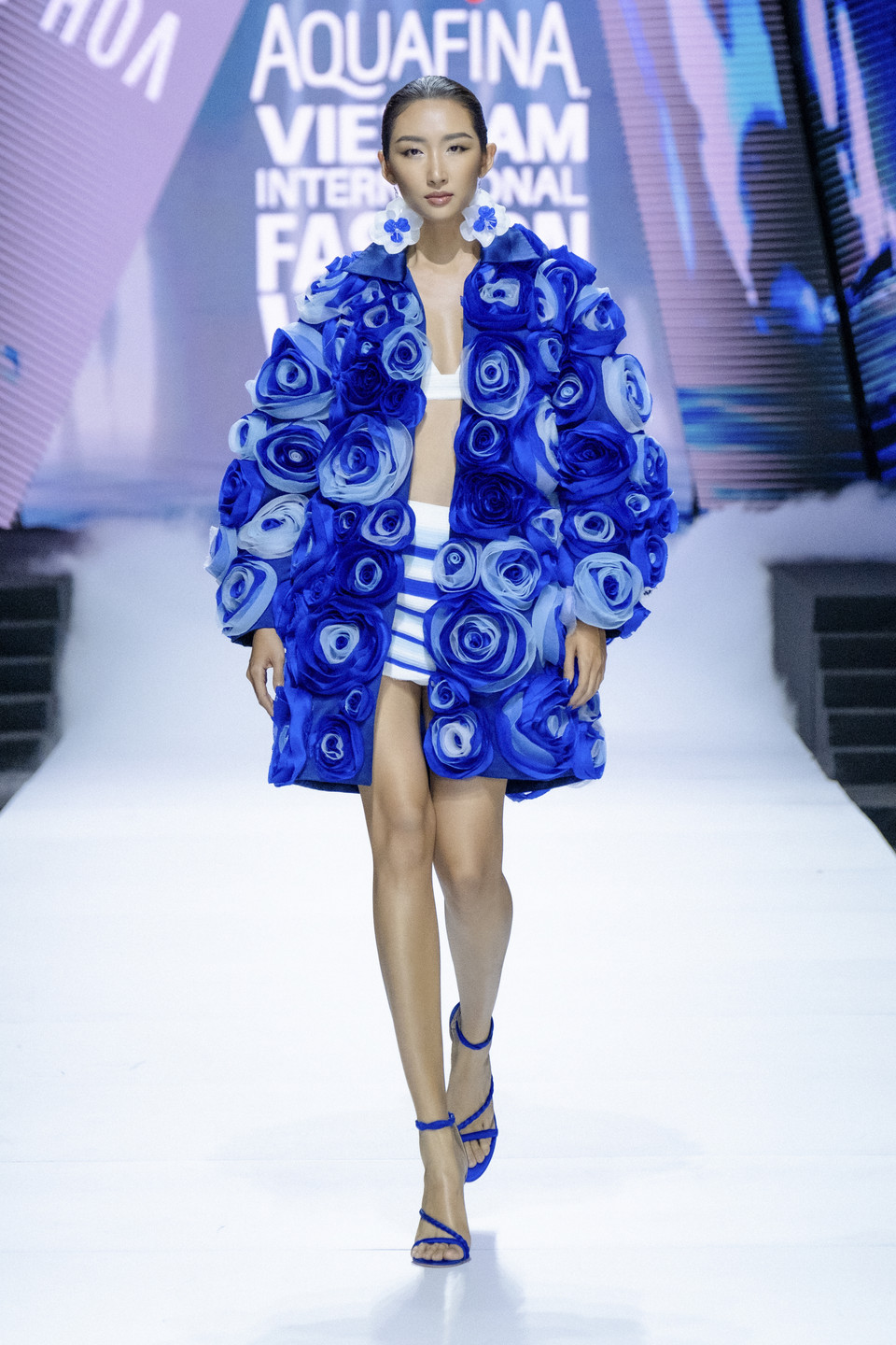 Nhà tạo mẫu đã khắc họa hình ảnh người phụ nữ kiêu hãnh ẩn mình dưới vẻ đẹp mềm mại của những đóa hoa xinh trên mặt hồ gợn sóng. (Ảnh: PV/Vietnam+)