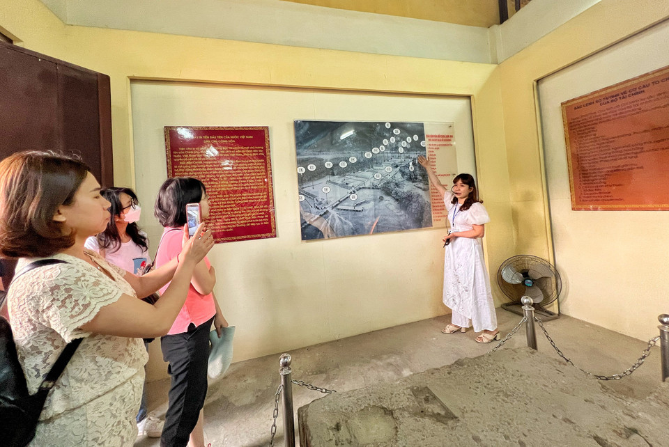 Hướng dẫn viên Bùi Thanh Hường giới thiệu về quy mô nhà máy in tiền đầu tiên của nước Việt Nam Dân chủ Cộng hòa. Nơi đây có hai dãy nhà xưởng in tiền – trước đó là đồn điền của một người Pháp, về sau được ông Đỗ Đình Thiện mua lại. (Ảnh: Mai Mai/Vietnam+)