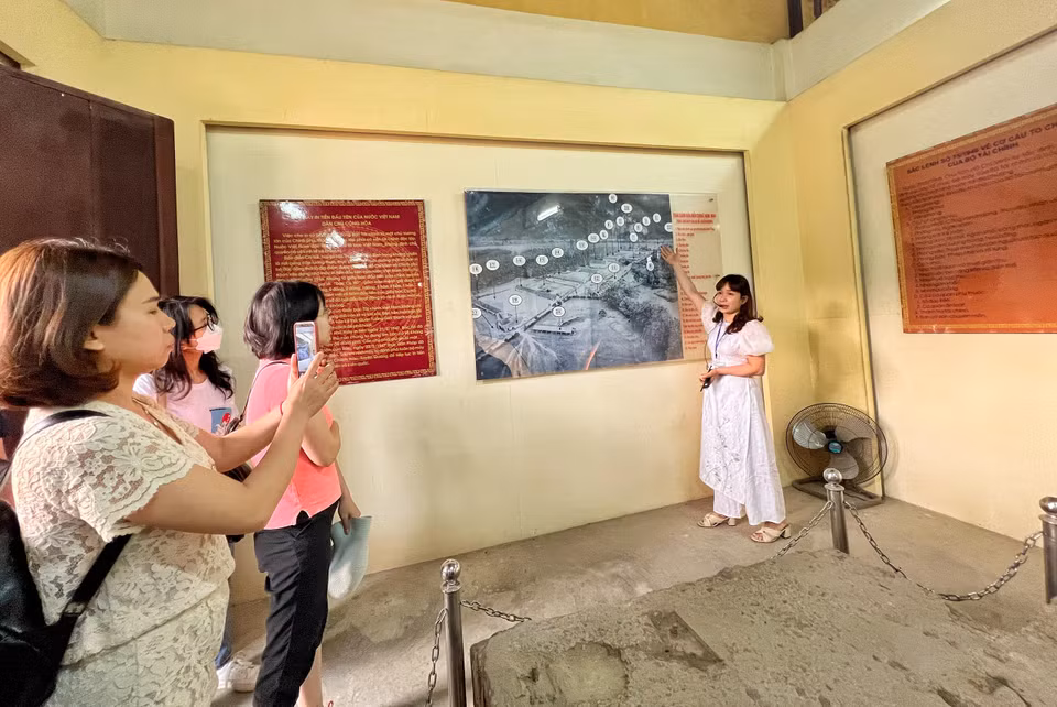 Hướng dẫn viên Bùi Thanh Hường giới thiệu về quy mô nhà máy in tiền đầu tiên của nước Việt Nam Dân chủ Cộng hòa. Nơi đây có hai dãy nhà xưởng in tiền – trước đó là đồn điền của một người Pháp, về sau được ông Đỗ Đình Thiện mua lại. (Ảnh: Mai Mai/Vietnam+)