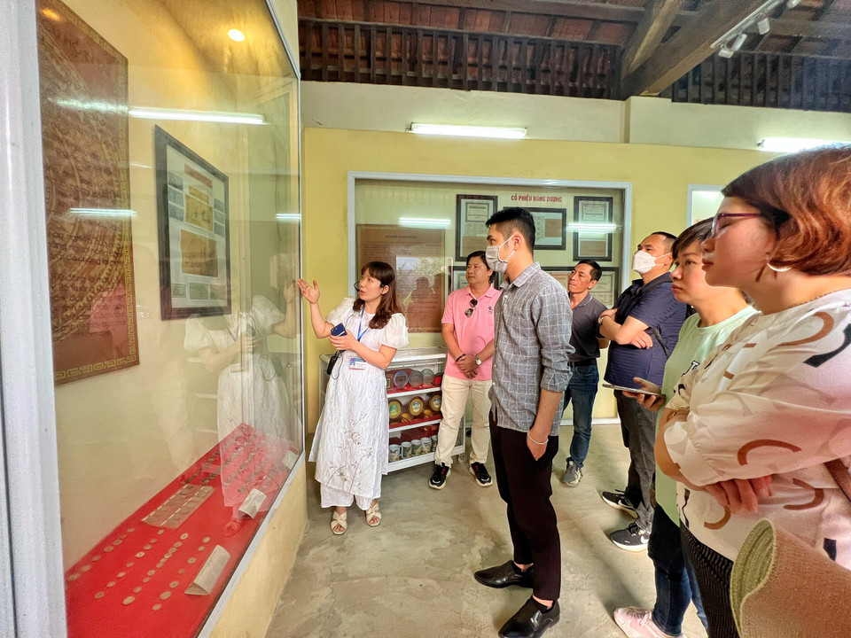 Hướng dẫn viên giới thiệu đồng tiền Việt Nam qua các thời kỳ. (Ảnh: Mai Mai/Vietnam+)