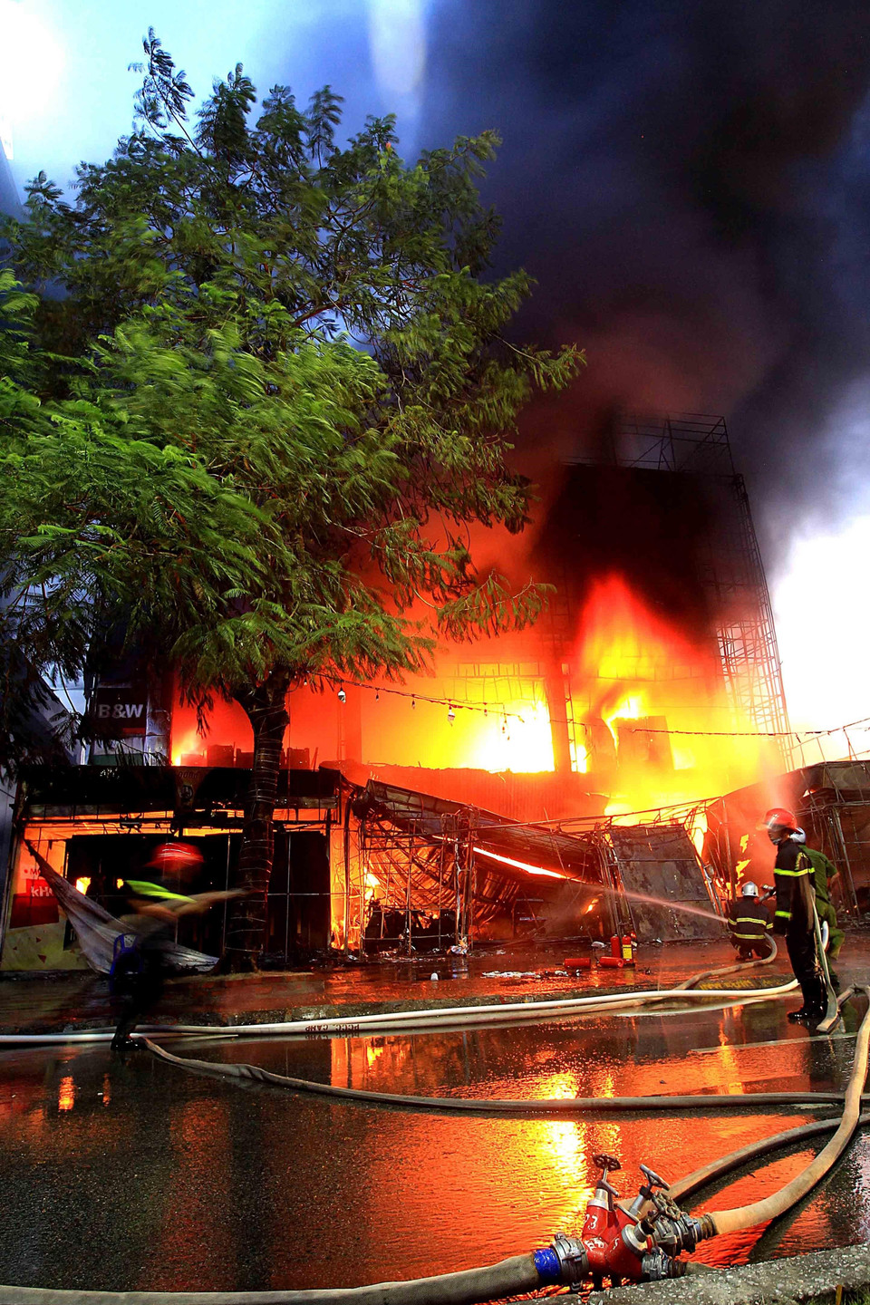 Các lực lượng chức năng đang dập lửa tại hiện trường. (Ảnh: An Đăng/TTXVN)