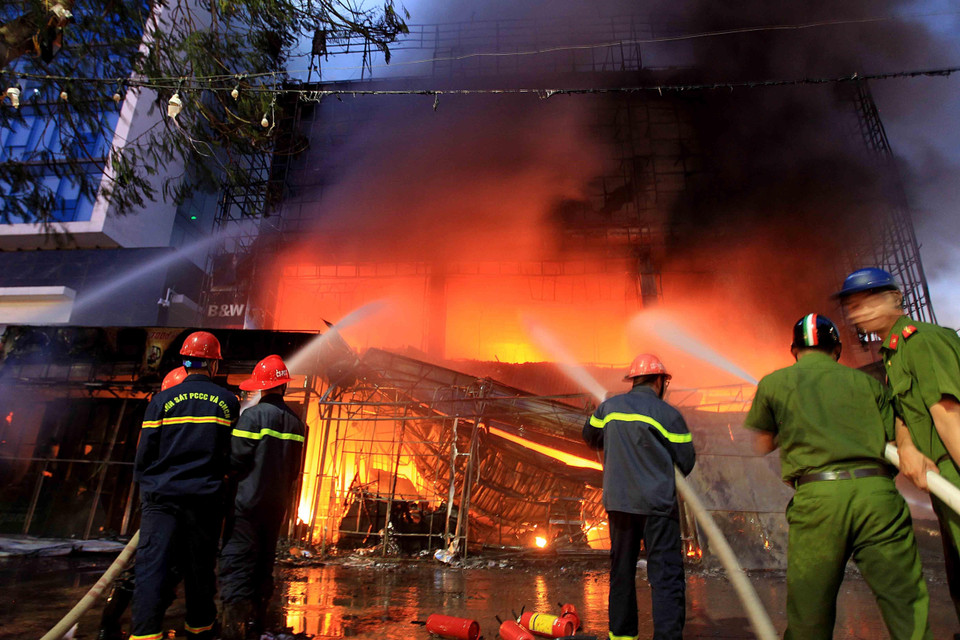 Các lực lượng chức năng đang dập lửa tại hiện trường. (Ảnh: An Đăng/TTXVN)