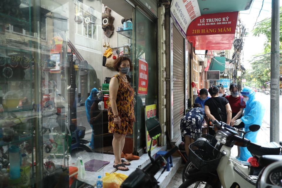 Người dân trong khu vực phong tỏa tạm thời phố Hàng Mắm chờ lấy mẫu xét nghiệm COVID-19. (Ảnh: Minh Quyết/TTXVN)