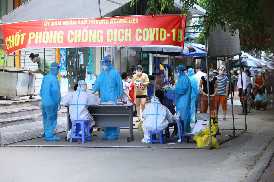 Lực lượng y tế quận Hoàng Mai lấy mẫu xét nghiệm cho người dân tòa HH4A. (Ảnh: Hoàng Hiếu/TTXVN)