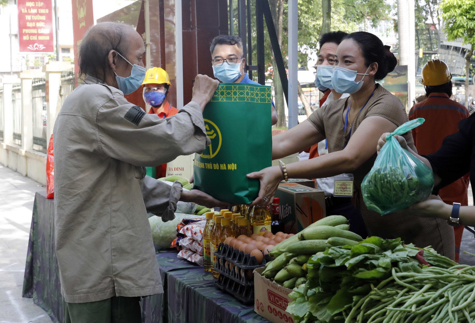 Những người có hoàn cảnh khó khăn nhận những suất quà từ gian hàng 0 đồng. (Ảnh: Trần Việt/TTXVN)
