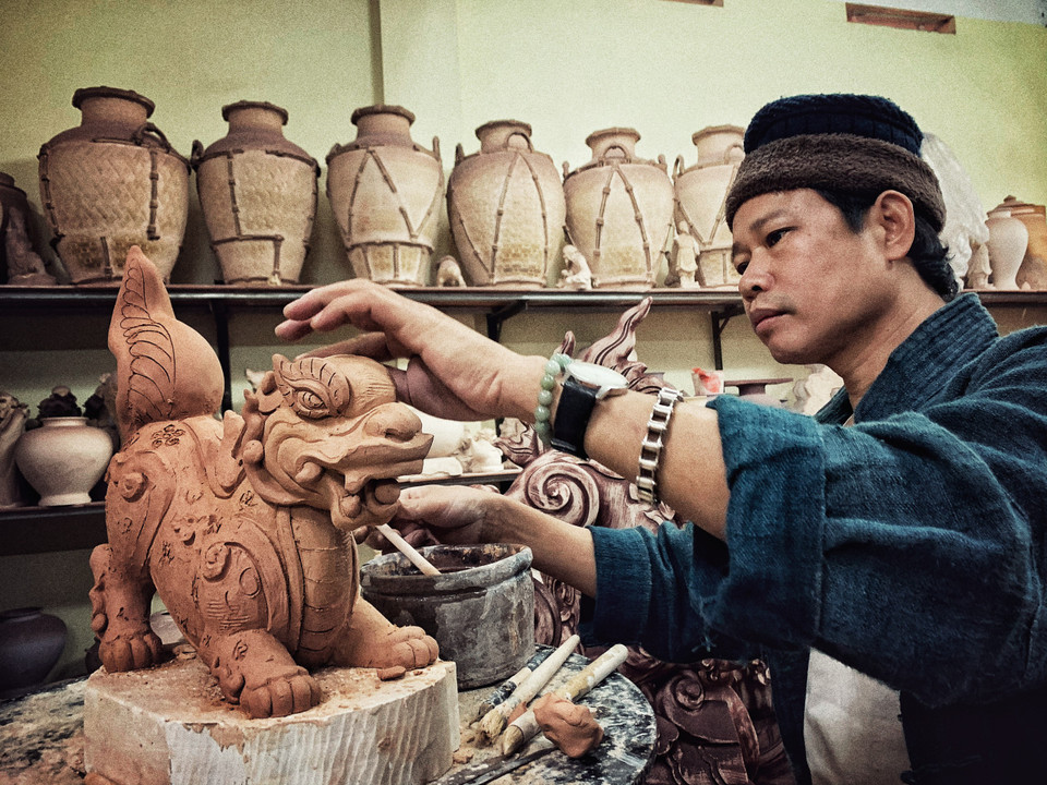 Anh đang hoàn thiện cặp Sấu thời Lý. (Ảnh: Xuân Mai/Vietnam+)